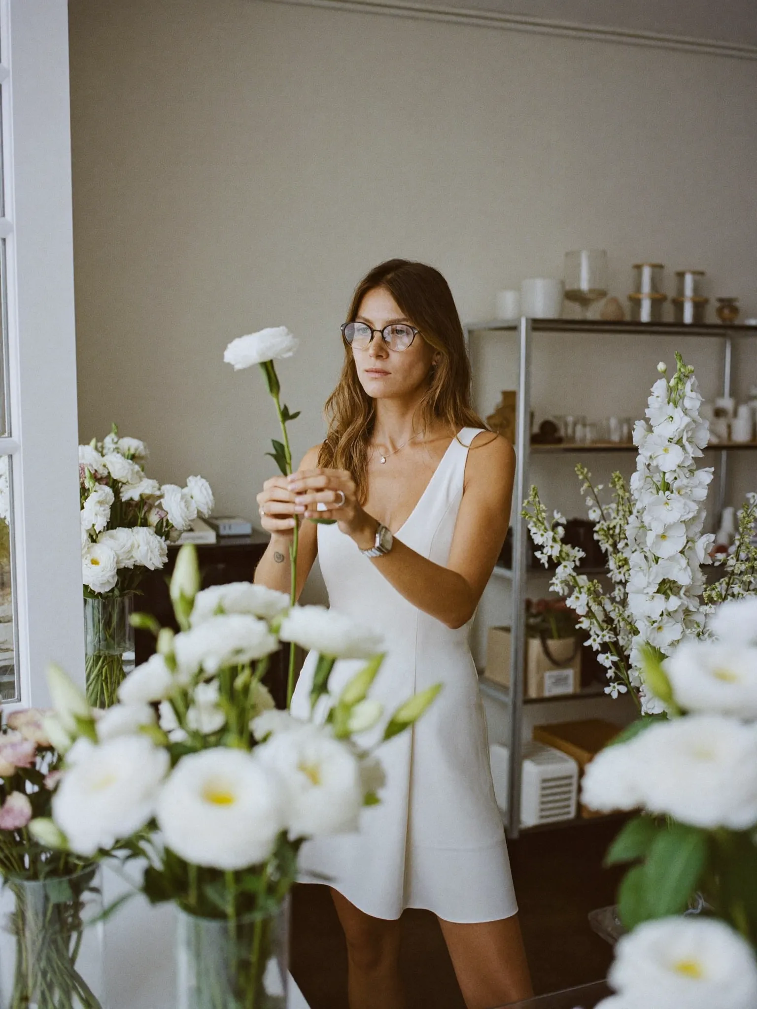 Sofia among white arrangements in her Milan florist studio